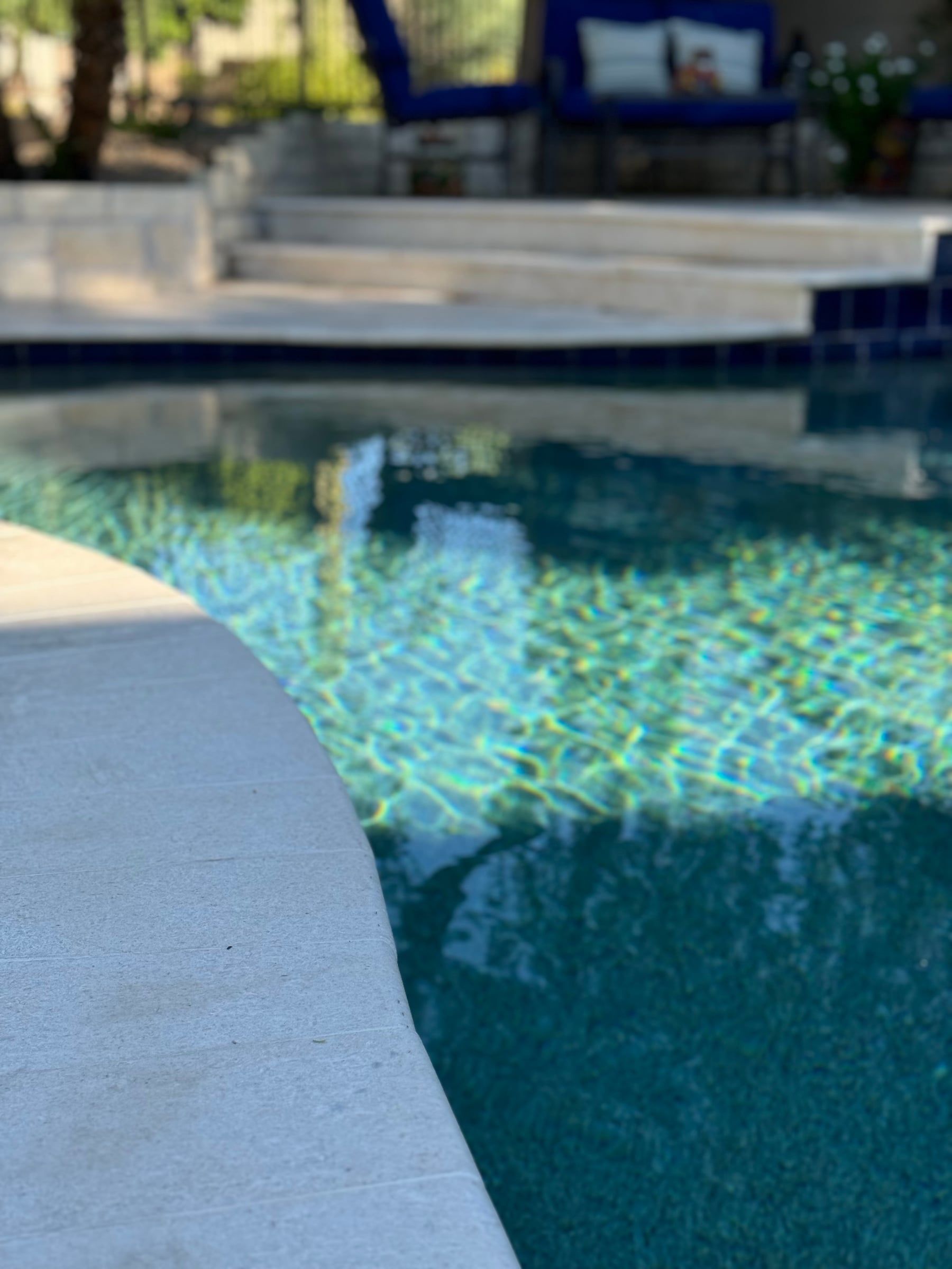 Clear, sparkling pool water along a curved deck